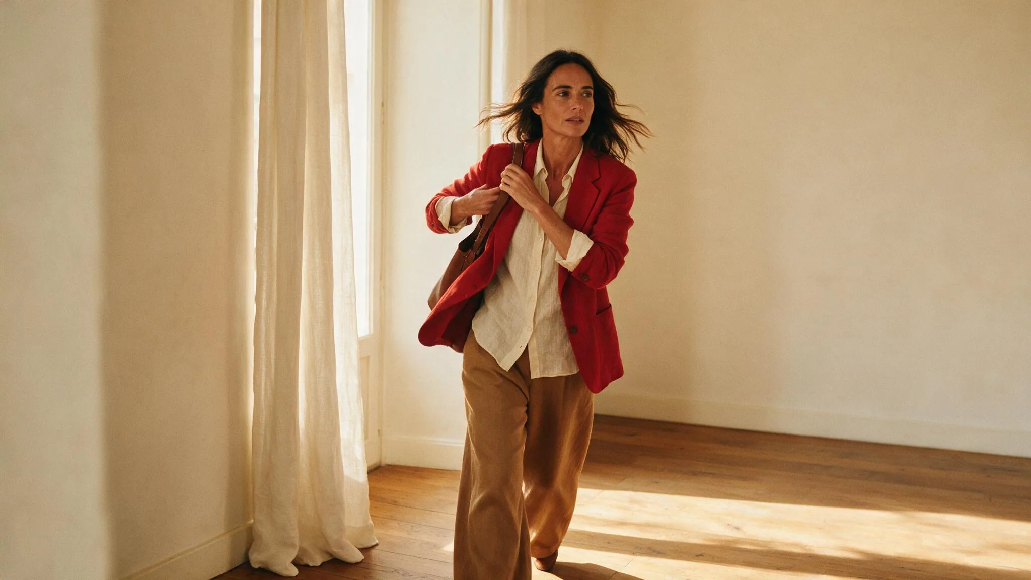 Mujer con blazer roja combinada con camisa cruda y pantalón camel, un ejemplo de qué colores combinan con el rojo